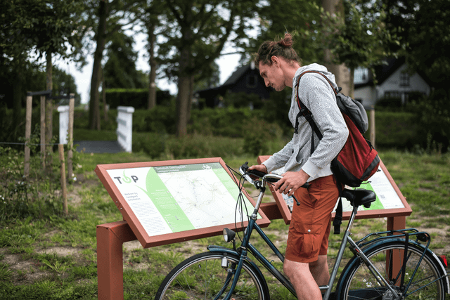 Fietser kijkt op informatiepaneel Toeristisch Overstappunt Landgoed Linschoten