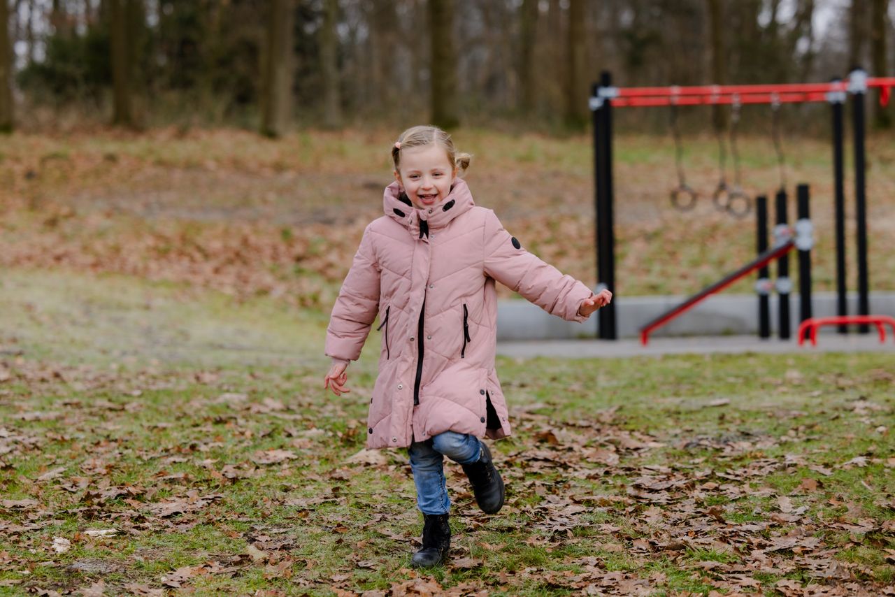 Een meisje loopt op het gras in de winter