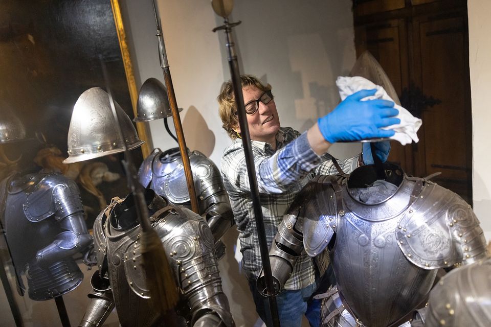 Museumvrijwilliger poetst de harnassen in het Muiderslot.
