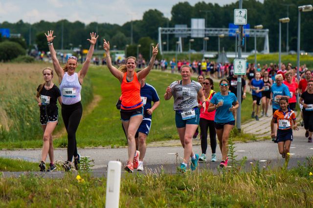 Vrouwelijke hardlopers zwaaien tijdens het hardlopen bij de Almere City Run in Flevoland