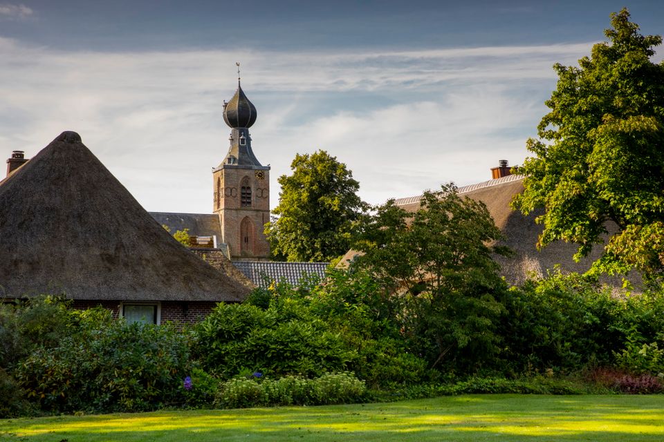 Dorpsaanzicht van Dwingeloo met een kerktoren op de achtergrond.