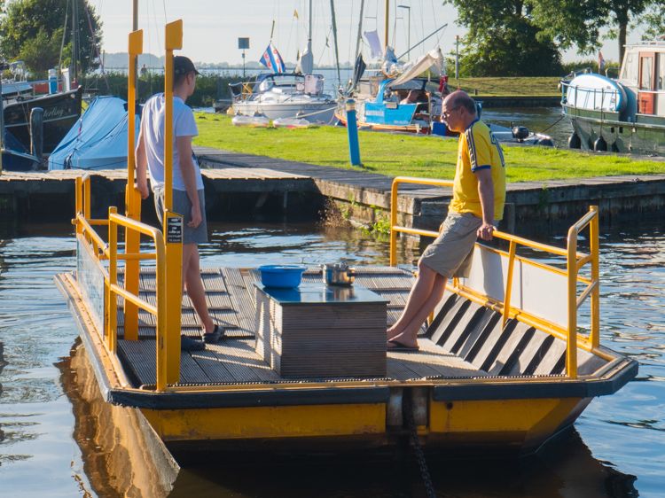 Bezoekers van de jachthaven maken gebruik van het pontje