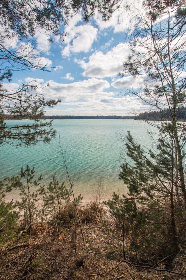 Ein Ausblick auf ein Gewässer mit klarem, blauem Wasser und einem Himmel voller Wolken.
