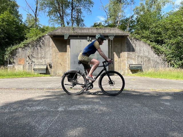 Imke van de Venne fietst langs een opslagbunker op vliegbasis Soesterberg
