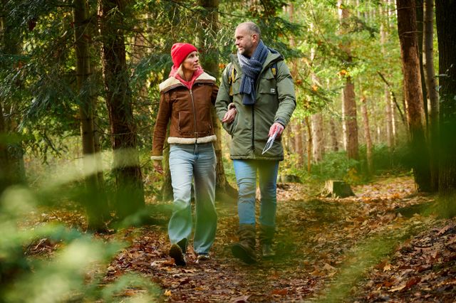 Een stel wandelt een kroegjesroute door de bossen van Gaasterland in de herfst