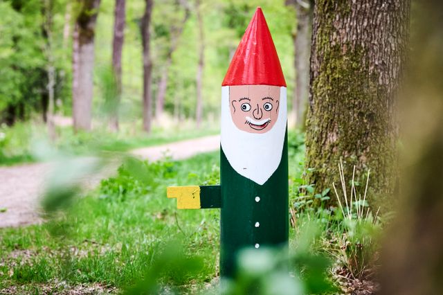Houten beschilderde kabouter in het bos.