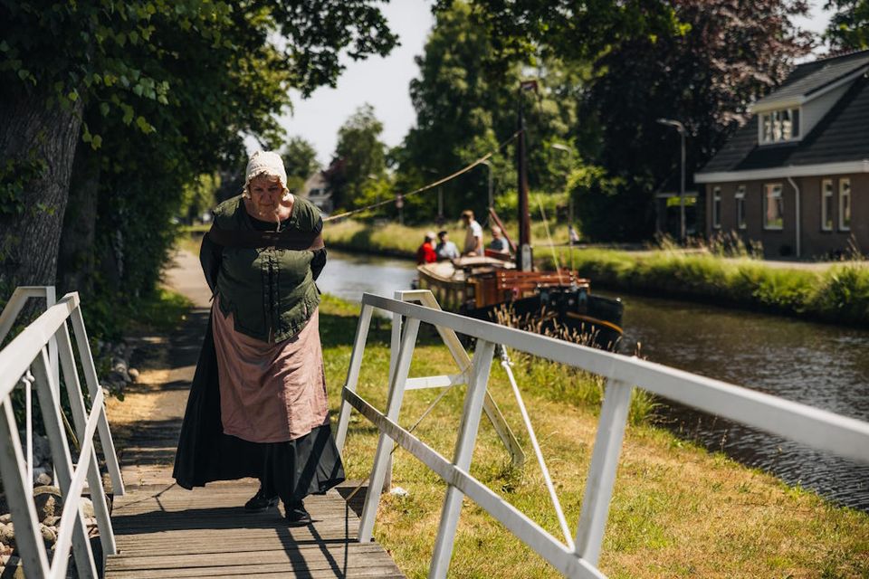 Eine Frau zieht auf traditionelle Weise eine Trekschuit in Drenthe.