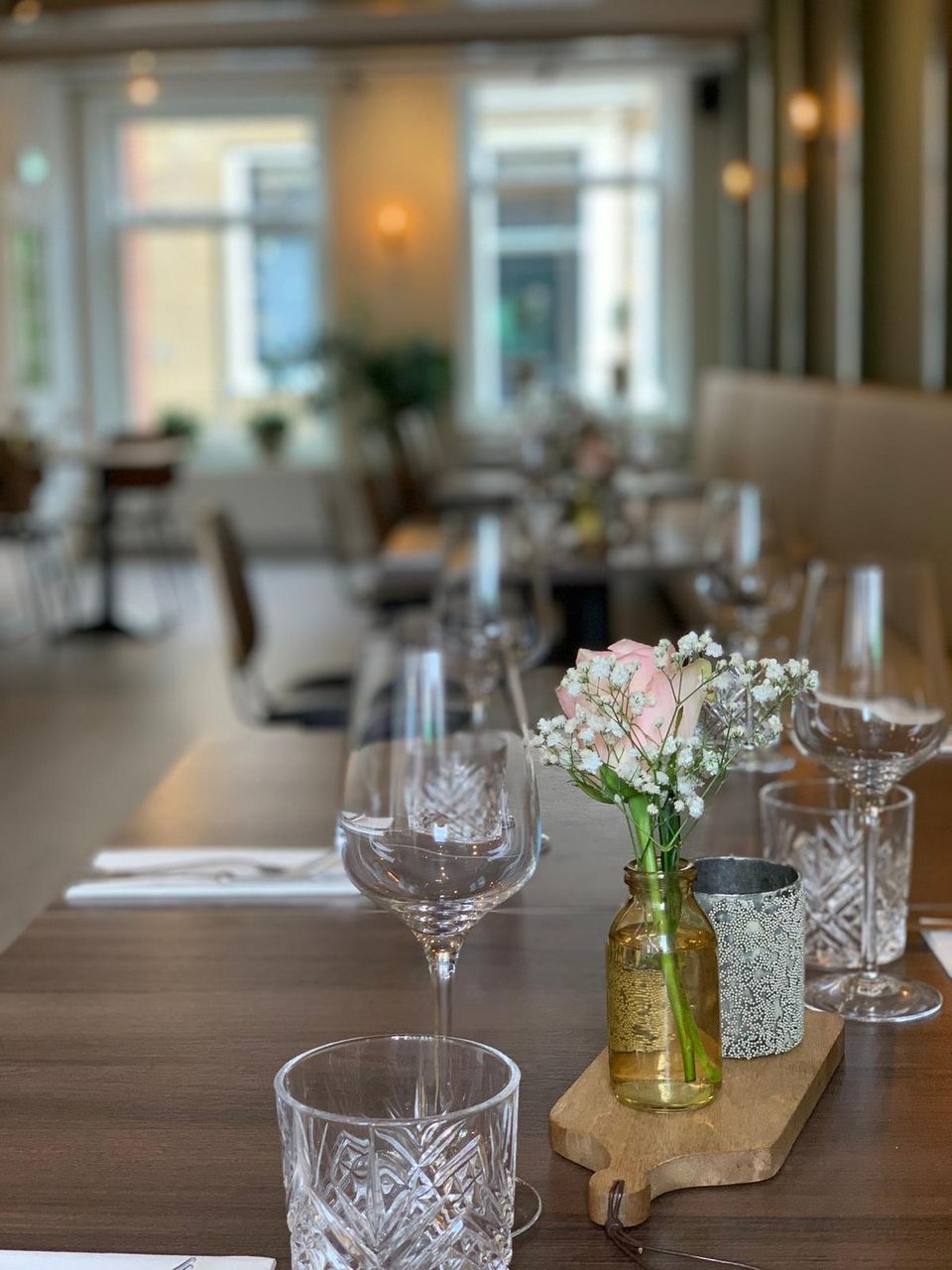 Restaurant Voldaan in Oudewater, Groene Hart, sfeervol interieur met gedekte tafels, wijnglazen en bloemen.