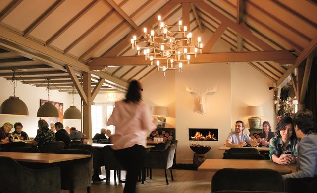 Indeling van Bosrestaurant De Belvertshoeve met tafels waaraan gasten zitten.