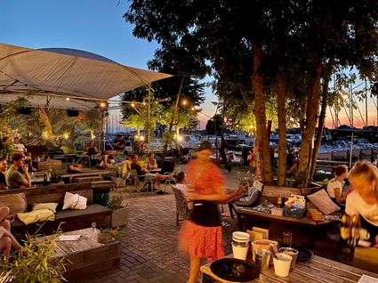 Haventerras de Koken bij De Drijfveer in Akkrum in het donker met water op de voorgrond.