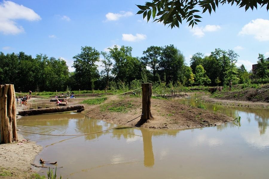 Speelweide op Landgoed Bredius in Woerden met water en natuurlijke speelelementen, avontuurlijk buitenspelen in het groen.