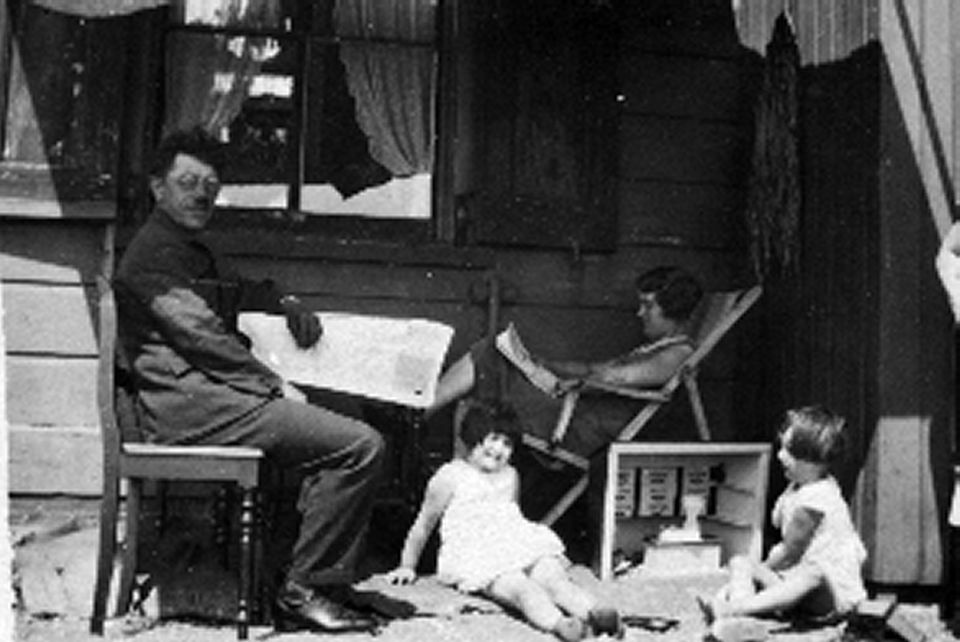 Zwart-wit foto van Fortwachter Kees van der Wagt 1929-1933 met zijn vrouw en twee kinderen op de veranda van het fortwachtershuis van Pampus.