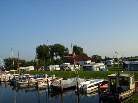 Verschillende bootjes liggen aan een steiger bij Camping Synneveer.
