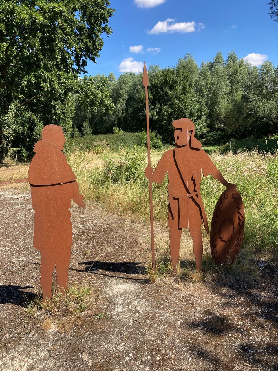 Twee stalen Romeinen naast een watertje.