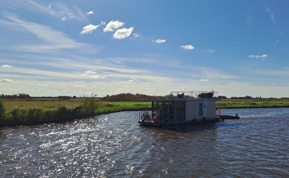 De Campi 300 Houseboat van Yachtcharter De Drait varend over het water met een blauwe lucht.