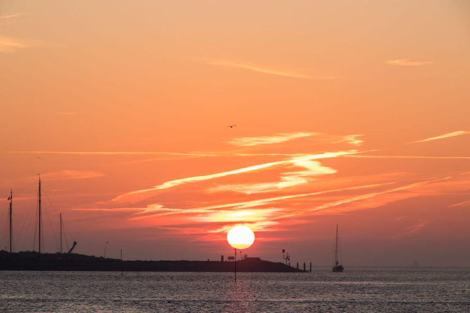 Silhouet van de jachthaven Vlieland bij opkomende zon