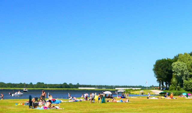 Recreanten op het gras van strand Voorland bij Blaricum op een zomerse dag.