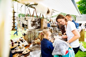 Moeder en kinderen bij een marktkraampje op de lentefair.