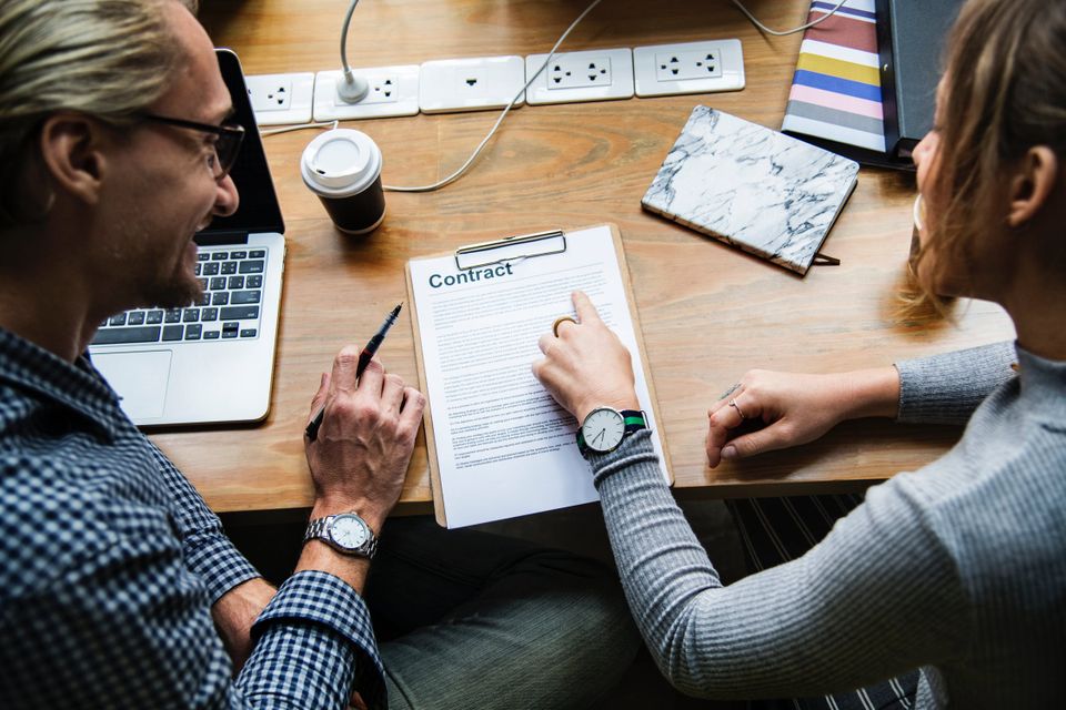 Two business people looking at a contract together
