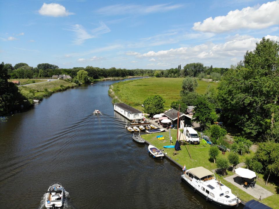 Een rivier met boten en groen gras op de kade.