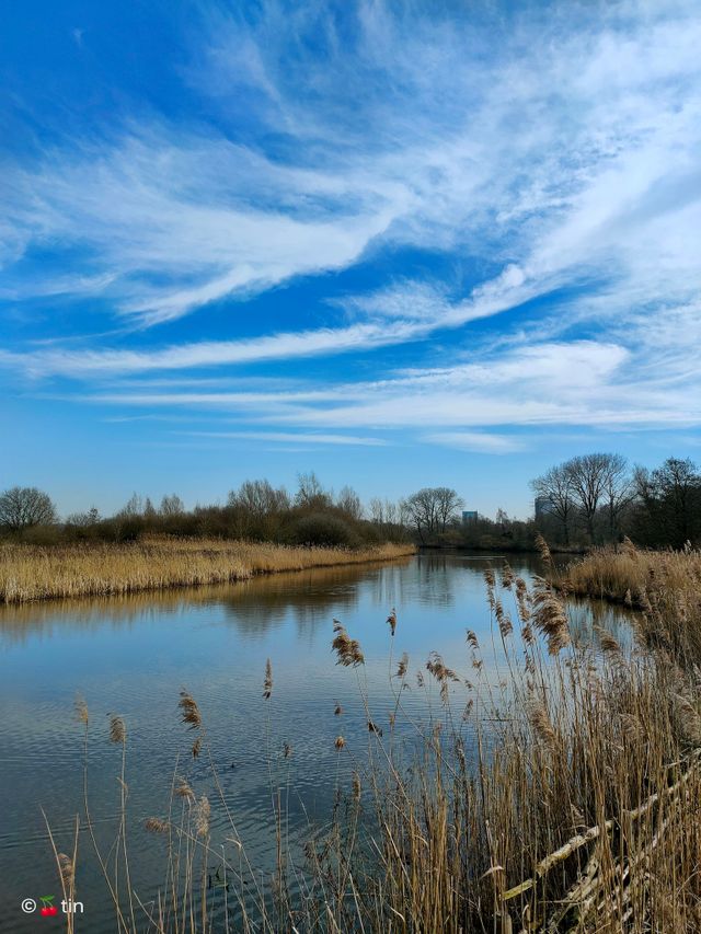Water van Ossermeer met blauwe lucht en witte strepen.