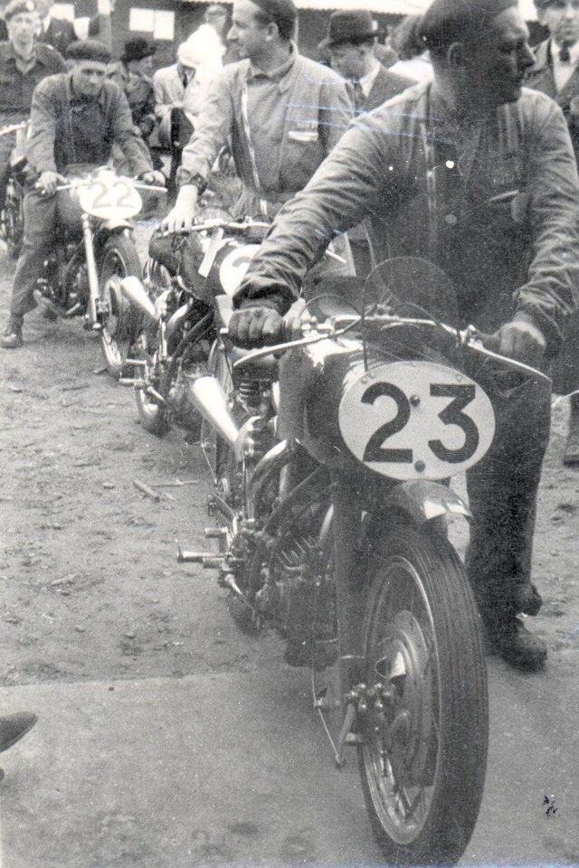 Drie 500cc Moto Guzzi racemotoren worden door fabrieksmonteurs naar de keuring gebracht. Op de voorgrond No. 23 is de machine van Bob Forster, daarachter de Guzzi van Enrico Lorenzetti en achter de machine van Guido Leoni.
