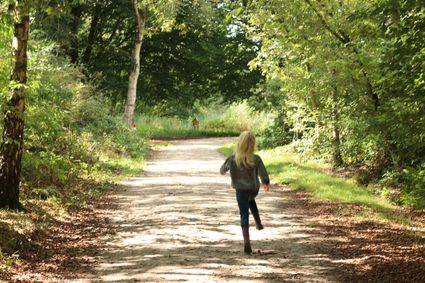 Een meisje die huppelt door het kabouterbos in Sint Nicolaasga.