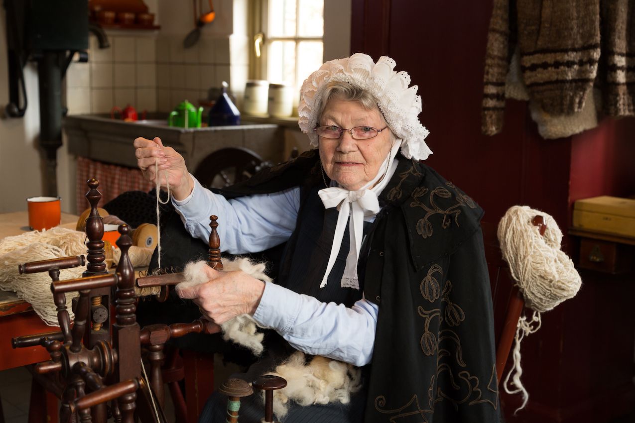 Woman spinning in traditional costume in Boerenbondsmuseum Gemert
