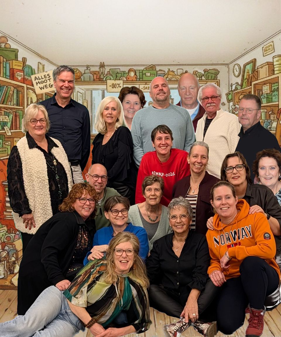 Op de foto is een groepsfoto te zien van de cast van Amicitia in een kringloopwinkel