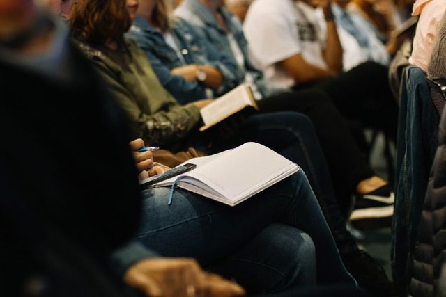 Congresdeelnemers met notitieblok op schoot