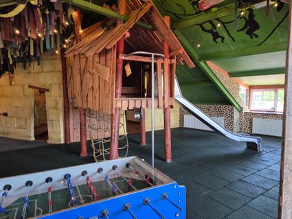 Binnenspeeltuin De Ontdekking met tafelvoetbalspel en klimtoren.
