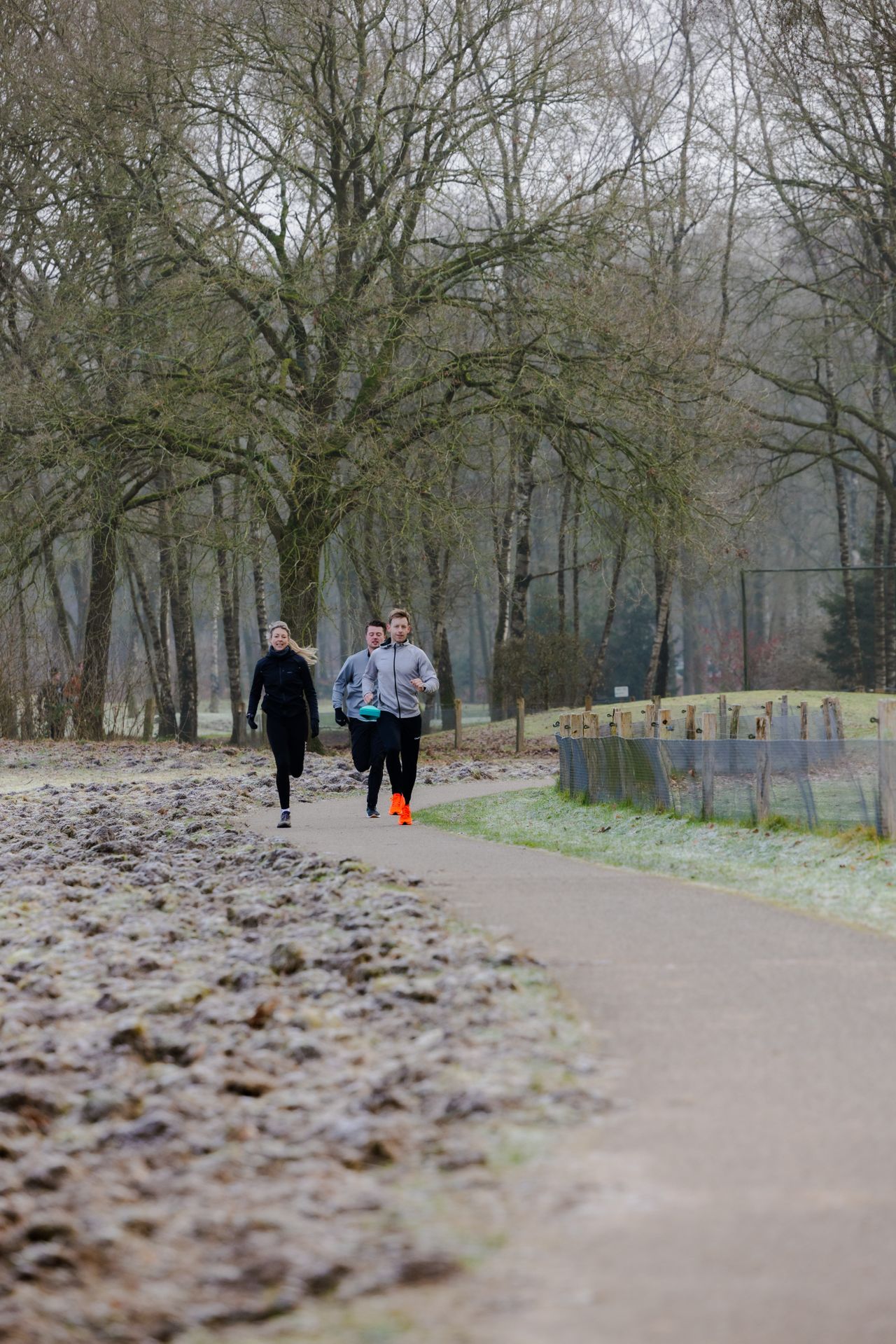 Twee mannen en een vrouw hardlopend in de winter