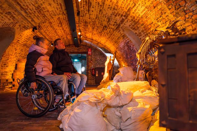 Bezoekers in een rolstoel in de kelder bij Kasteel Helmond