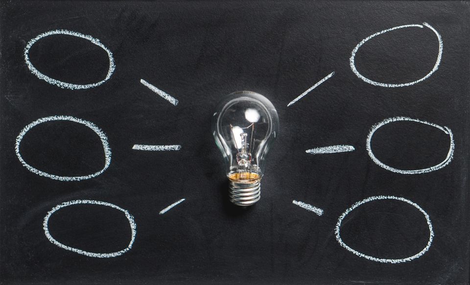 Light bulb surrounded by speech bubbles