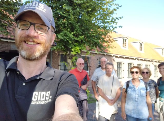 De gids Peter Bos met een groep wandelaars in Veenhuizen