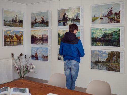 Het MonetAtelier van binnen met diverse schilderijen.