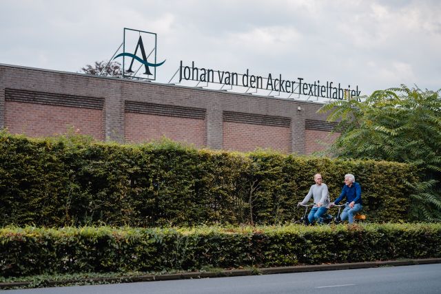 Anton en Kees fietsen langs voormalige textielfabriek Johan van den Acker Textielfabriek