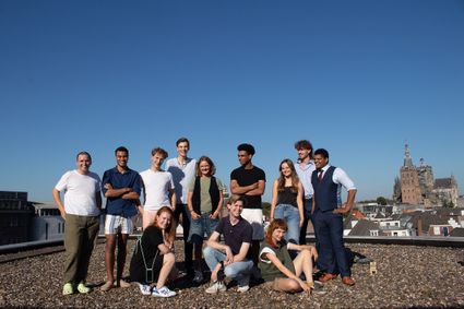 Foto van jongeren die op een plat dak staan in de binnenstad