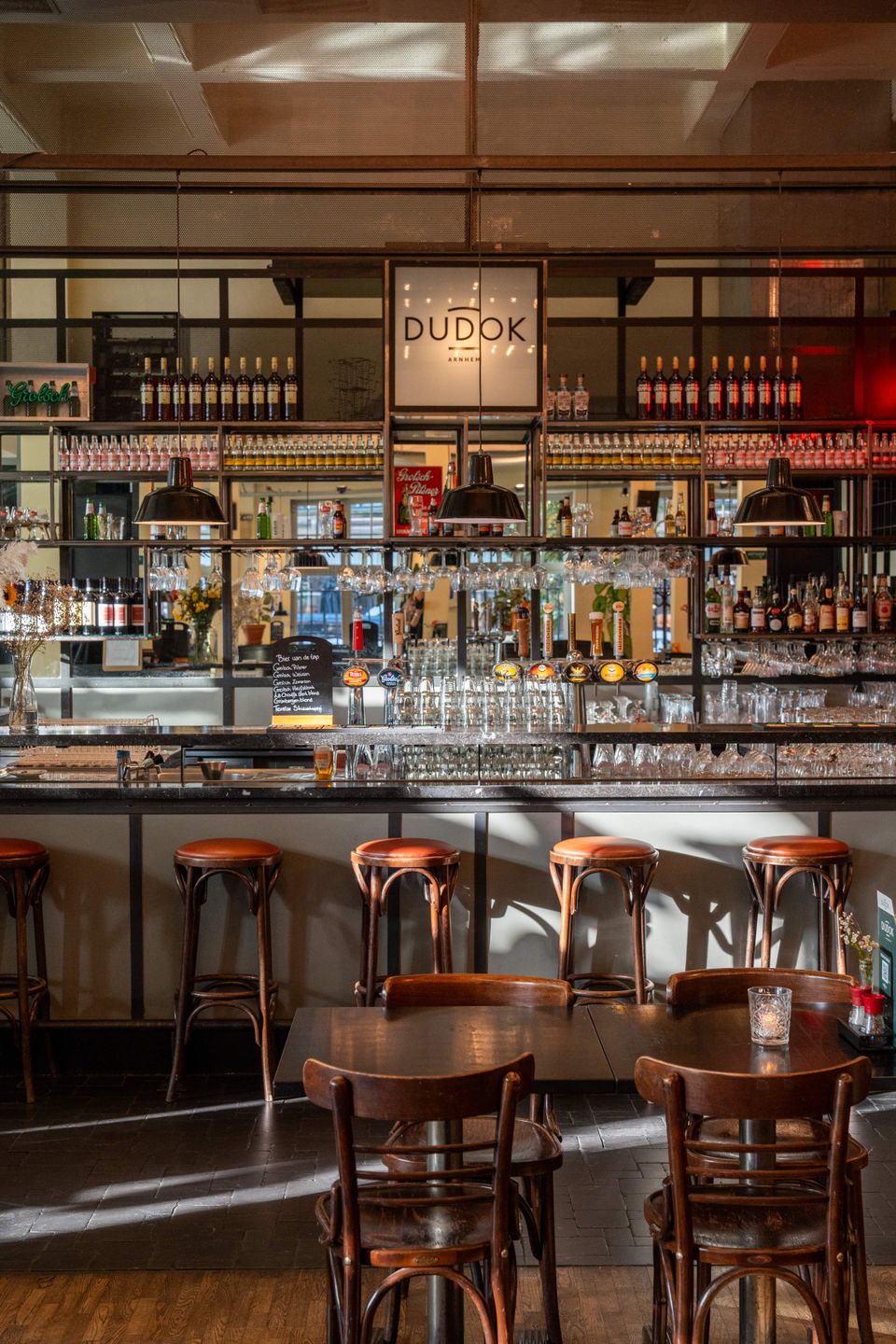 Een stijlvolle bar met een lange toonbank en enkele krukken, ideaal om van een drankje te genieten in een gezellige sfeer.