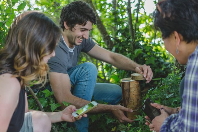 Een groep vind een geocache bij een boom