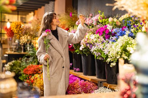 Vrouw zoekt tussen de bloemen bij Rootz