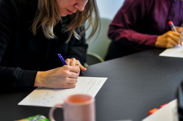 persoon schrijft met pen in opschrijfboekje