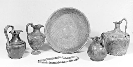 Grafvondsten uit Geldermalsen: bronzen kannen en een grote bronzen schaal. De halsketting zou mogelijk dateren uit rond 500-700