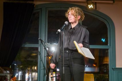 Vrouw op podium met boek in haar hand