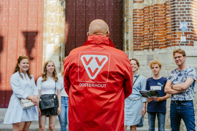 Gids op de rug genomen pratend tegen kinderen