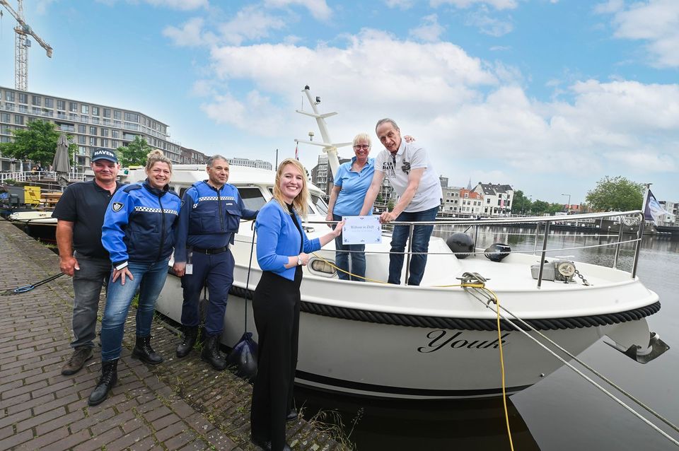 Wethouder Maaike Zwart overhandigt het eerste duurzame informatiepakket aan bezoekers in de Delftse passantenhaven