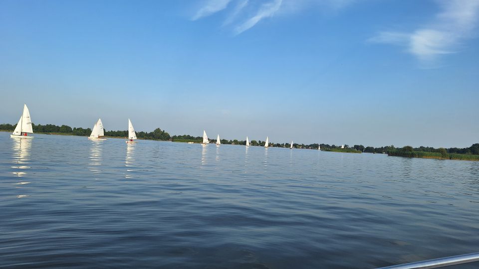 Recreatieplas Elfhoeven Plas, Reeuwijkse Plassen bij Reeuwijk, Groene Hart, zeilboten op rustig open water met lage oevers en rietkragen onder een blauwe zomerlucht in een populair watersportgebied.