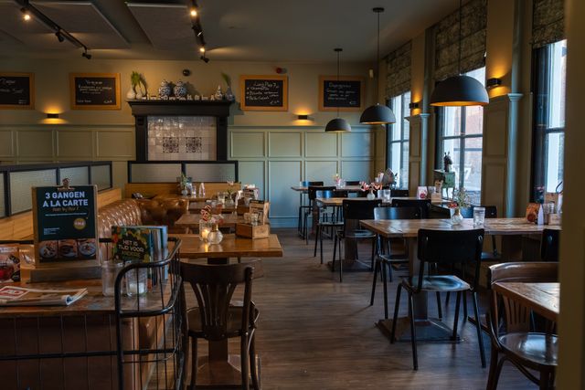 Restaurant Plein 7 in Woerden, Groene Hart, sfeervol restaurantinterieur met houten tafels, leren zitbanken, zwarte stoelen, hanglampen en krijtborden met gerechten.