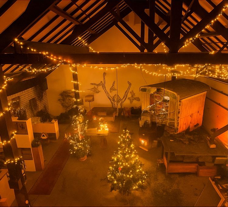 Atelier Mainkunstenaars in kerstsfeer met haardvuur en kerstboom- en lichtjes