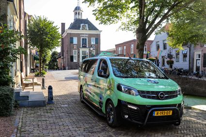 Een groen busje op straat geparkeerd